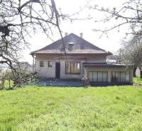 Ein Einfamilienhaus in der Jalovcova-Straße in Bratislava - Koliba, umgeben von einem Garten und Bäumen.