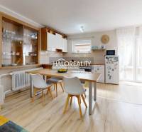 Interieur eines Einfamilienhauses mit Esstisch, Küche und Regalen für Geschirr.
