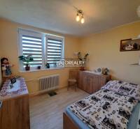 Schlafzimmer im Einfamilienhaus mit Holzmöbeln und Zimmerpflanzen.