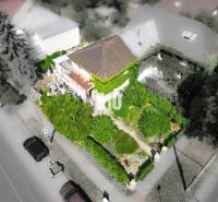 Ein Einfamilienhaus in Bratislava - Staré Mesto, umgeben von dichtem Grün und Bäumen.