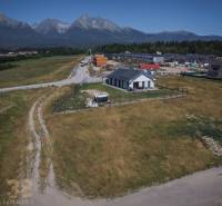 Grundstücke zum Wohnen in Mlynica mit Blick auf die Tatra, ein Landhaus und Gebäude im Hintergrund.