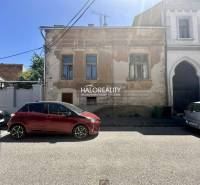 Eine Straße in Rimavská Sobota mit einem historischen Familienhaus und geparkten Autos.