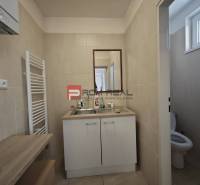 Badezimmer mit Waschbecken und WC in der Šúrska-Straße, in der Nähe des Büros, helle Fliesen.