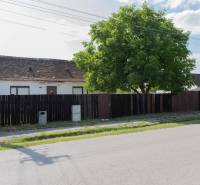 Ein Gebäude mit einem alten Dach in der Športová-Straße in Gajary, umgeben von einem Zaun. Grundstücke - Wohnen.
