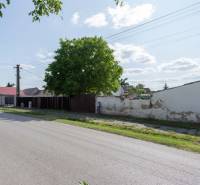 Sportová Straße in Gajary mit Grundstücken zum Wohnen, neben der Straße und den Bäumen.