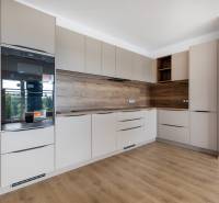 Küche in einer 3-Zimmer-Wohnung mit Holzboden und eingebauten Geräten.