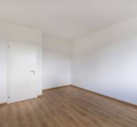 Ein leerer Raum mit weißen Wänden und Holzboden, geeignet für eine 3-Zimmer-Wohnung.