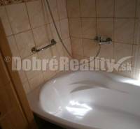 Badezimmer in einem Einfamilienhaus mit Badewanne und Duschkopf.