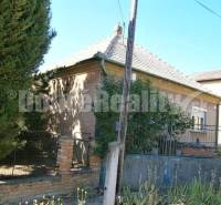 Ein Einfamilienhaus in Rúbaň mit einem älteren Äußeren, umgeben von einem Zaun und Vegetation.