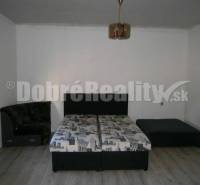 Schlafzimmer im Einfamilienhaus mit Bett, Sofa und Holzboden.