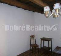 Einfach eingerichtetes Zimmer in einem Einfamilienhaus mit Holzdecke und Holzboden.