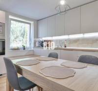 Küche in einem Einfamilienhaus mit Esstisch, eingebauten Geräten und großem Fenster.