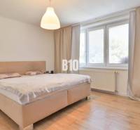 Ein Schlafzimmer in einem Einfamilienhaus mit einem großen Bett und minimalistischen Möbeln.