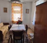 Esszimmer in einem Einfamilienhaus mit Tisch, Stühlen, Blumen, Teppich und Vorhang.