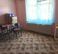 Ein Zimmer in einem Einfamilienhaus mit Teppichmuster und einem Tisch mit Stühlen.