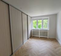 Ein Zimmer in einer 2-Zimmer-Wohnung mit Einbauschrank und Fenster, helle Parkettböden.