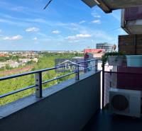 Blick vom Balkon auf die Stadtlandschaft, die Eisenbahn und das Grün von einer Einzimmerwohnung.