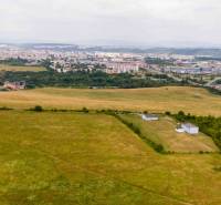 Landwirtschaftliche und forstwirtschaftliche Flächen in Košice, Stadtteil Luník IX, mit der Stadt im Hintergrund.