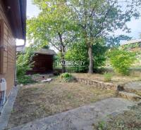 Holzbauten umgeben von Gras und Bäumen in Gärten in der Stadt Zvolen.