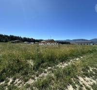 Grundstücke - Wohnen in Jamník, Rasenfläche mit Umgebung von Gebäuden und Wäldern, sonniger Tag.