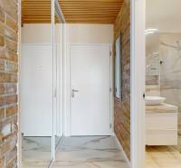 Flur und Badezimmer in einer 2-Zimmer-Wohnung mit einem Spiegelschrank und Ziegelwänden.