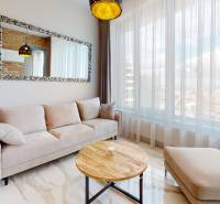 Heller Wohnbereich mit einem bequemen Sofa und einem großen Spiegel in einer 2-Zimmer-Wohnung.
