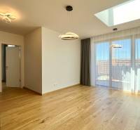Heller Wohnbereich mit Vorhängen, Holzboden und Küchenzeile in einer 2-Zimmer-Wohnung.