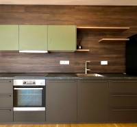 Küche in einer 2-Zimmer-Wohnung mit dunklen Möbeln und eingebautem Gerät.