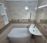 Badezimmer mit Duschwanne und Waschbecken in einer 3-Zimmer-Wohnung, Fliesen mit Naturmuster.