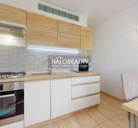 Küche in einer 3-Zimmer-Wohnung mit Holzschränken und Esstisch.