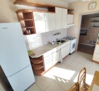 Küche einer 3-Zimmer-Wohnung mit weißen Geräten und Küchenzeile.