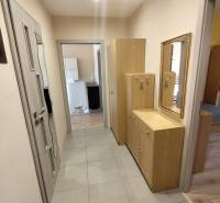 Ein Flur mit Fliesenboden und Holzmöbeln in einer 3-Zimmer-Wohnung.