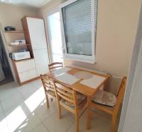 Esstisch mit Stühlen in der Küche einer 3-Zimmer-Wohnung, neben einem Küchenschrank.