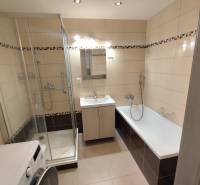 Badezimmer in einer 3-Zimmer-Wohnung mit Dusche und Badewanne, helle Fliesen.