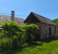 Ein Einfamilienhaus in Čelovce mit Anbau und Garten, umgeben von Grün.