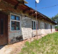 Ein Einfamilienhaus in Čelovce mit einer Steinfasade und einem grünen Grundstück.