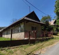Ein Einfamilienhaus in Čelovce mit einem Holzzaun und einem Satteldach in einer natürlichen Umgebung.