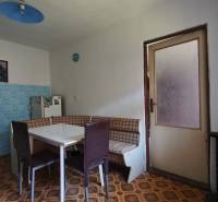 Küche in einem Einfamilienhaus mit Eckbank, blauen Fliesen und Tisch.