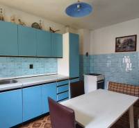 Eine Küche in einem Einfamilienhaus mit blauer Küchenzeile und Eckbank.