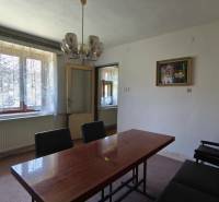 Esszimmer mit Holztisch, Vorhang und Kronleuchter in einem Einfamilienhaus.