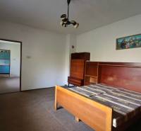 Schlafzimmer mit einem Holzbett und einem Schrank in einem Einfamilienhaus.