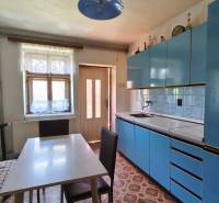 Küche in einem Einfamilienhaus mit blauer Küchenzeile, Esstisch und Bank.