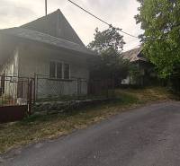 Ein Einfamilienhaus in Čelovce mit einer Steinmauer und ländlicher Atmosphäre in einer ruhigen Straße.