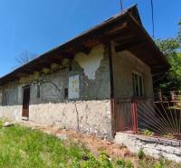 Ein Einfamilienhaus in Čelovce mit älterer Fassade, Rasen und einem Eisenzaun.