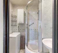 Badezimmer mit Waschmaschine und Duschkabine in einer 3-Zimmer-Wohnung.