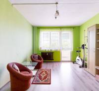 Das Wohnzimmer in der 3-Zimmer-Wohnung enthält Sofas, einen TV-Schrank und ein Fitnessfahrrad.