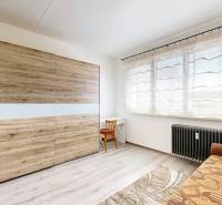 Ein Zimmer in einer 3-Zimmer-Wohnung mit einem Sofa, einem Schrank, einem Tisch und einem großen Fenster.