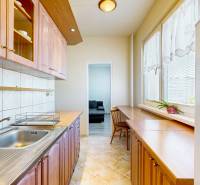 Küche in einer 3-Zimmer-Wohnung mit Holzschränken und Blick auf die Straße.