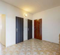 Eingangshalle in einer 3-Zimmer-Wohnung mit Holzmöbeln und Fliesen, neben dem Esszimmer.