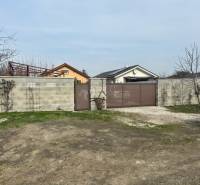 In Zálesí in der Straße Domky ist ein geschlossenes Tor und eine Betonmauer zu sehen, die landwirtschaftliche und forstwirtschaftliche Grundstücke umgeben.
